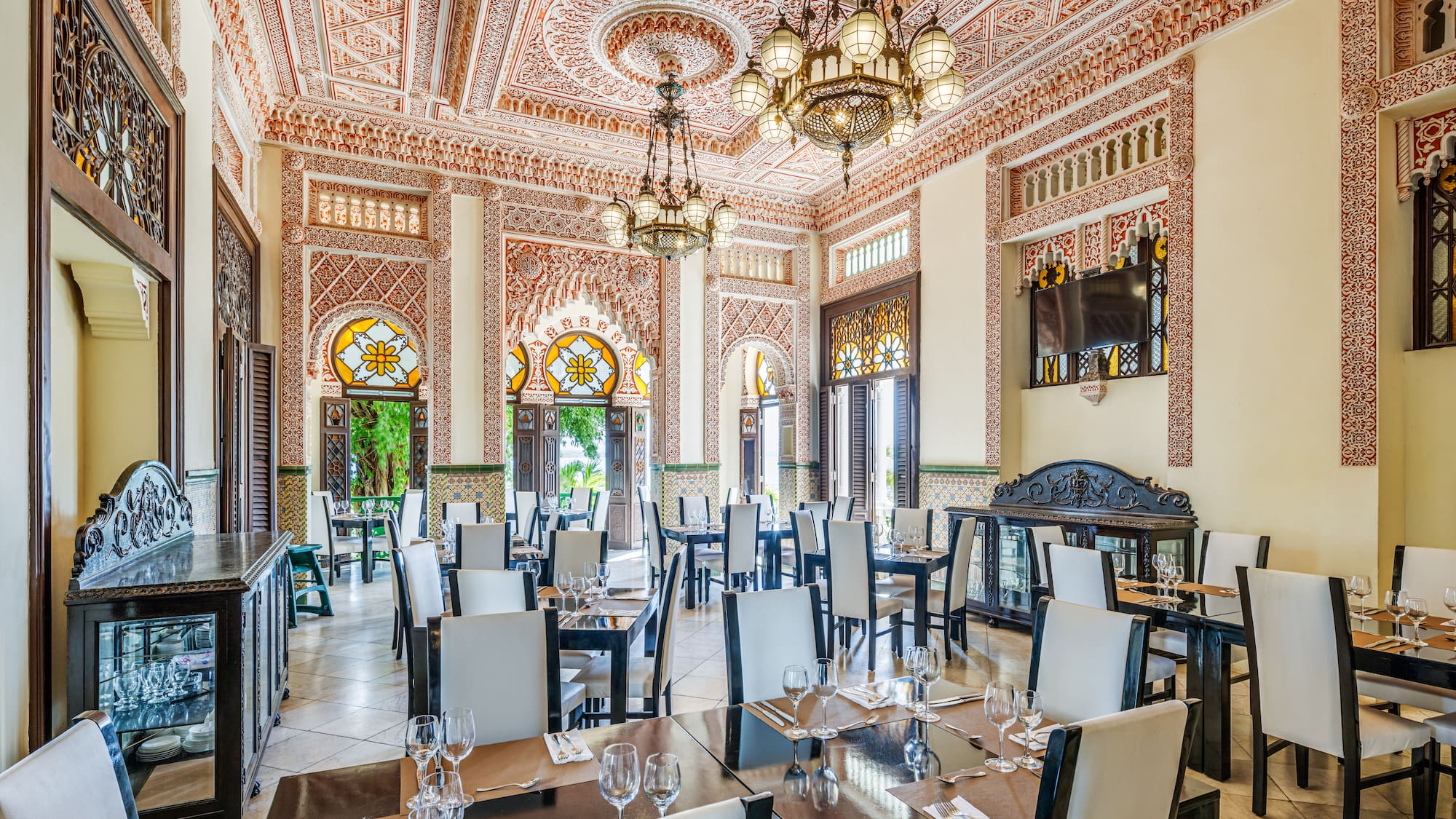 a room with ornate walls and tables and chairs