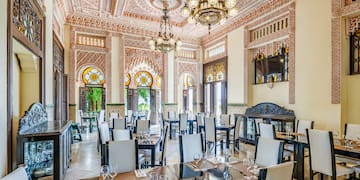 a room with ornate walls and tables and chairs