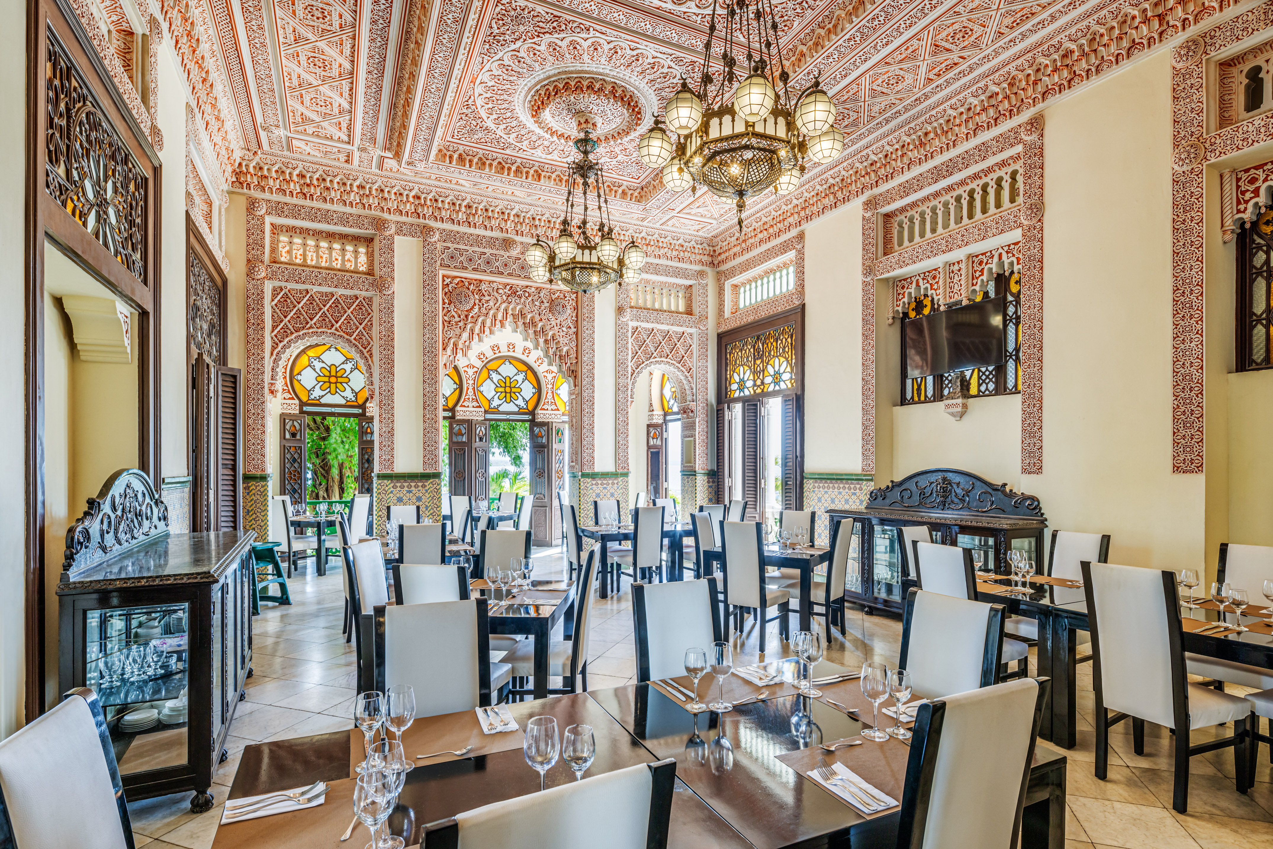 a room with ornate walls and tables and chairs