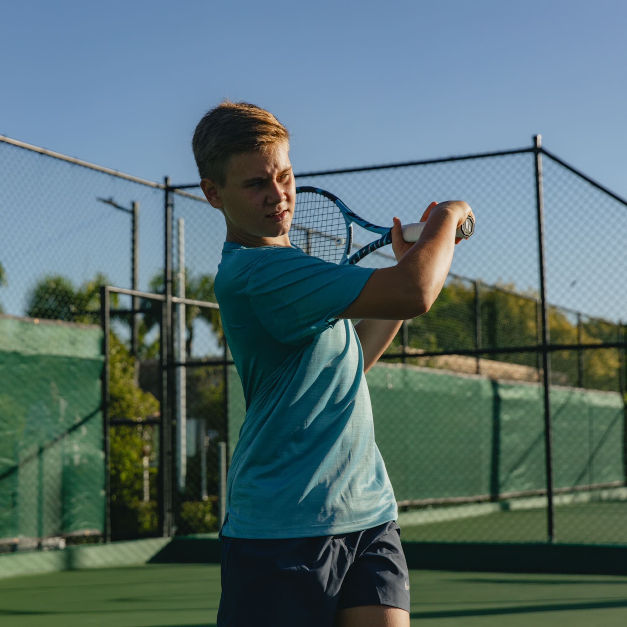 a boy holding a tennis racket