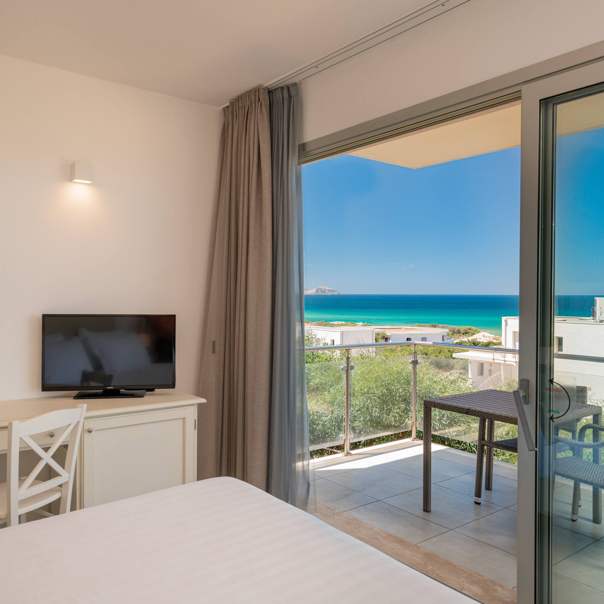 a room with a television and a view of the ocean