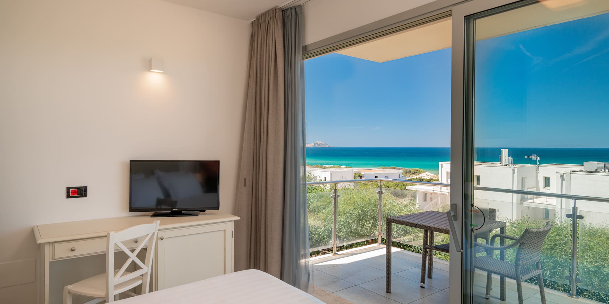 a room with a television and a view of the ocean