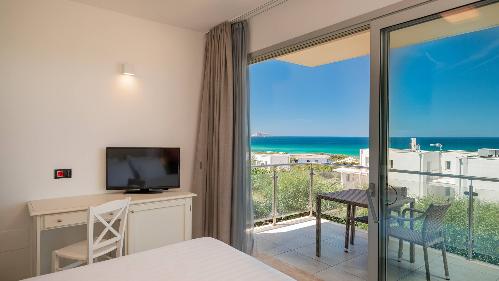 a room with a television and a view of the ocean