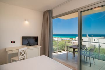 a room with a television and a view of the ocean