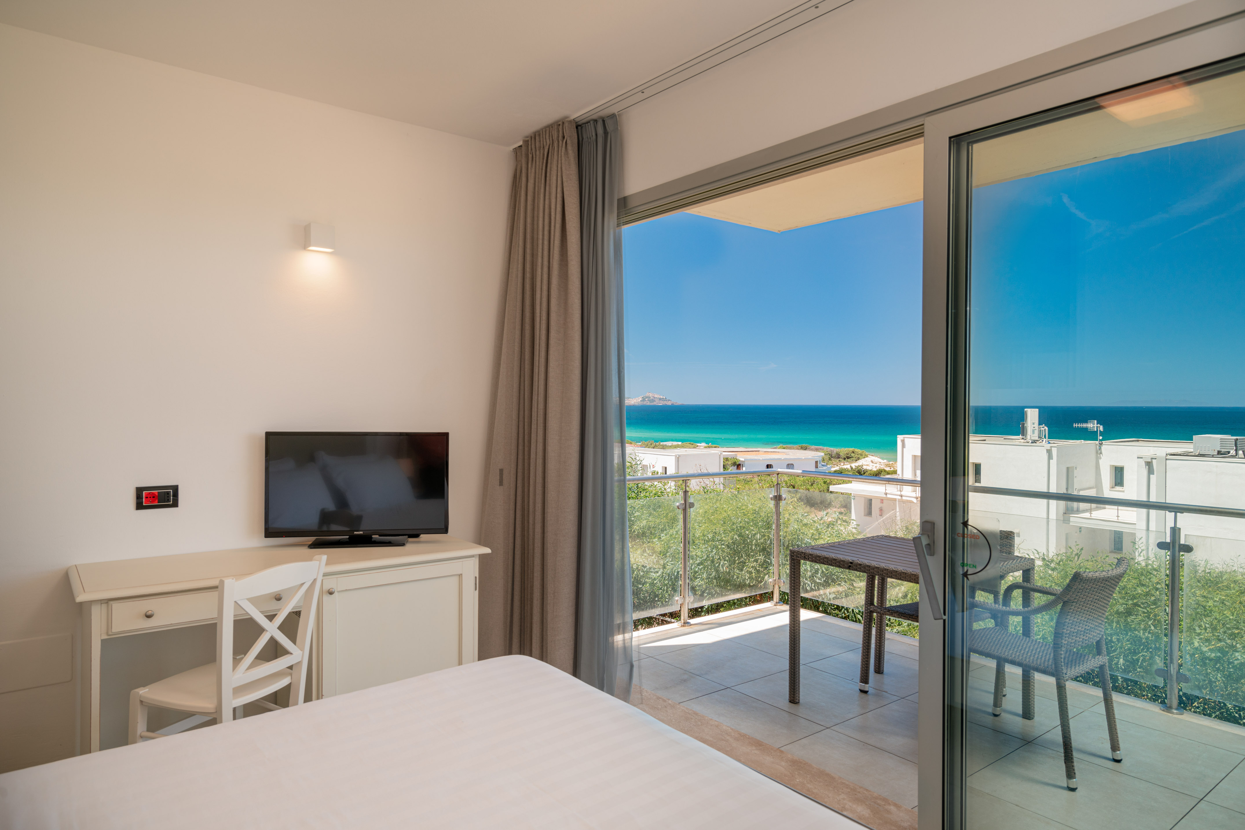 a room with a television and a view of the ocean