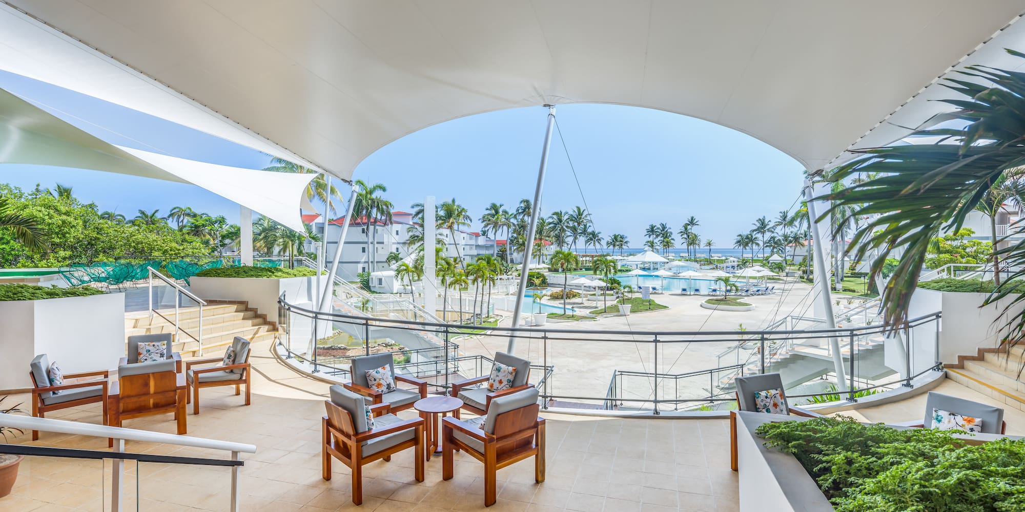 a patio with chairs and a view of the water from the deck