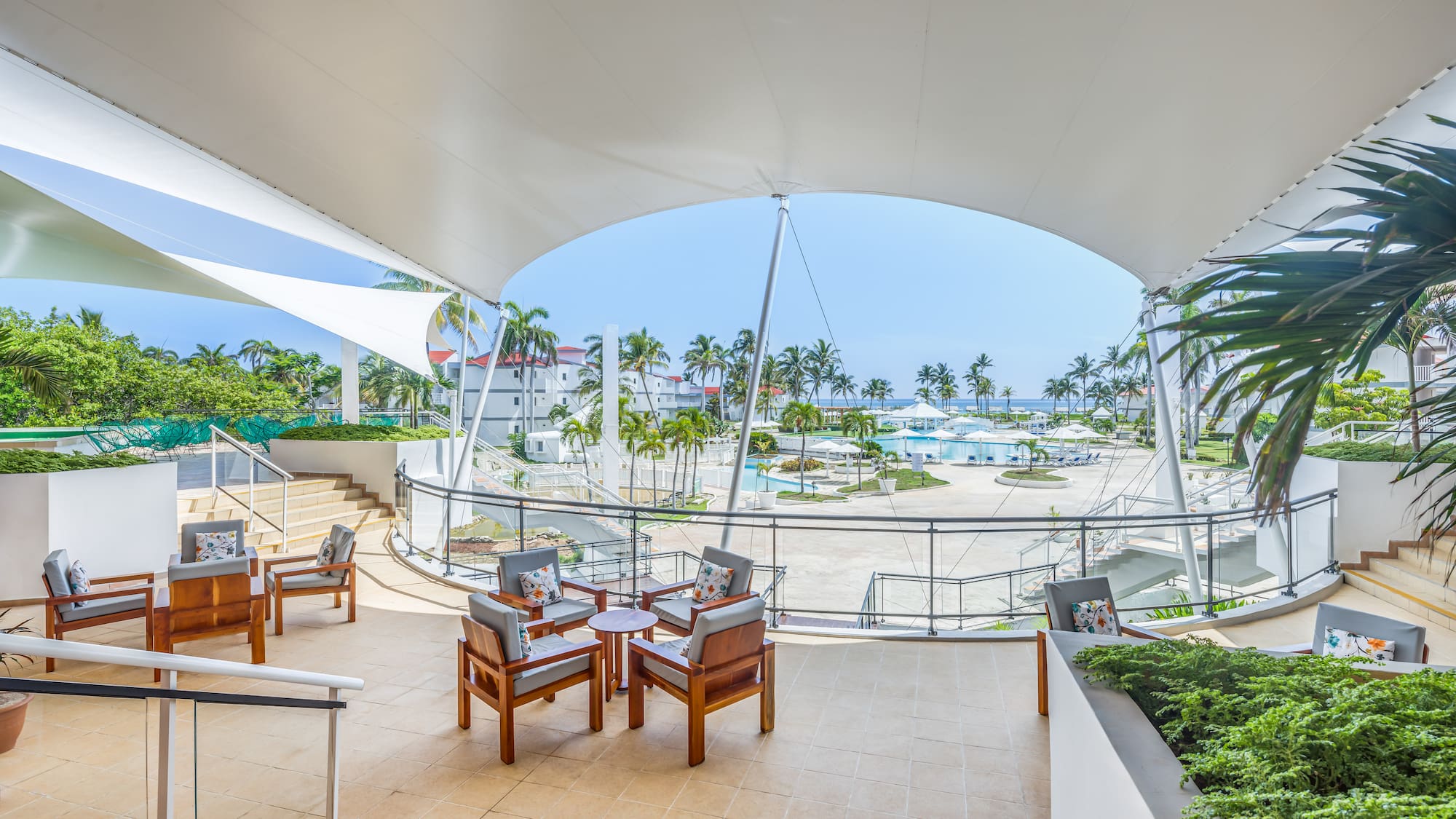 a patio with chairs and a view of the water from the deck