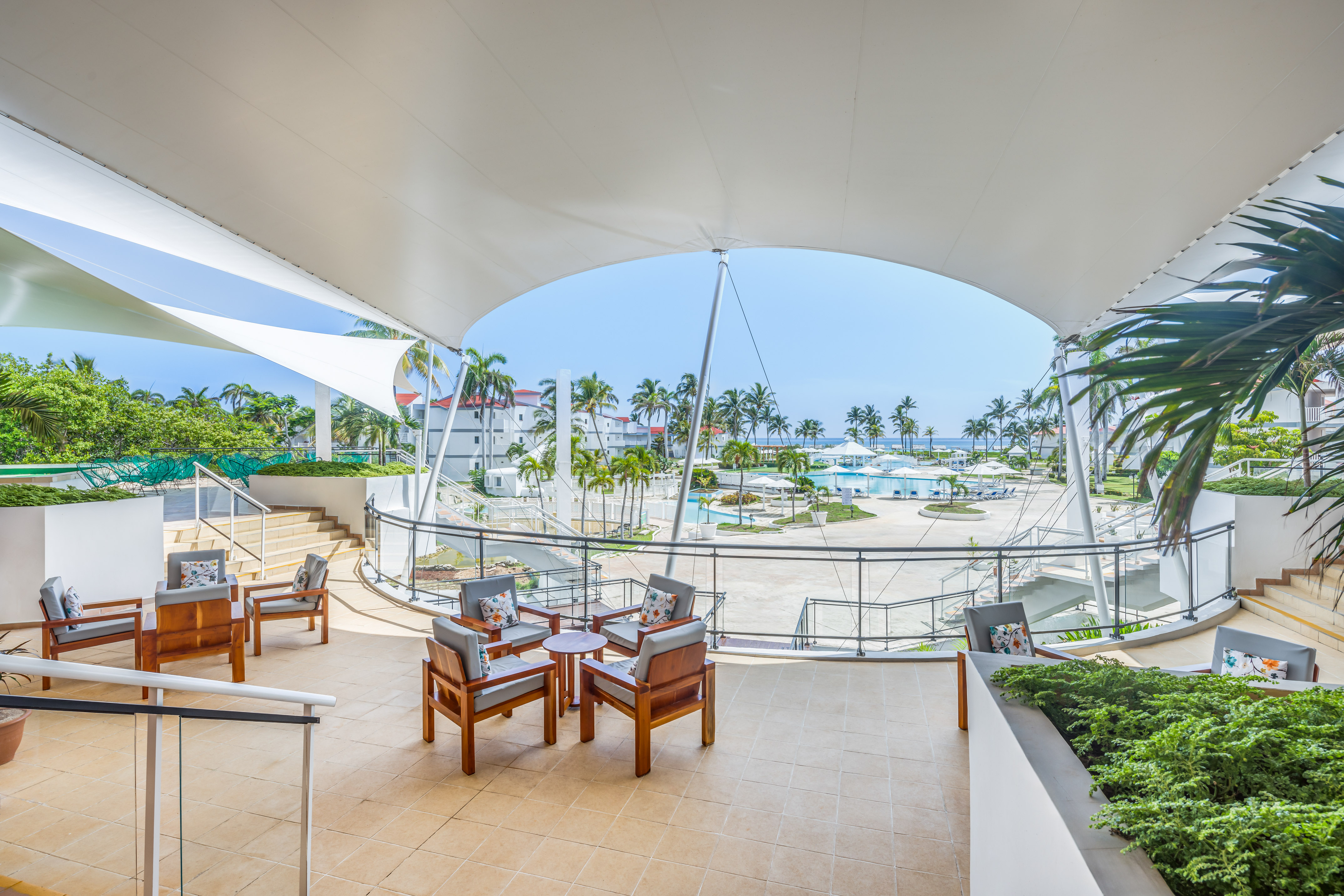 a patio with chairs and a view of the water from the deck