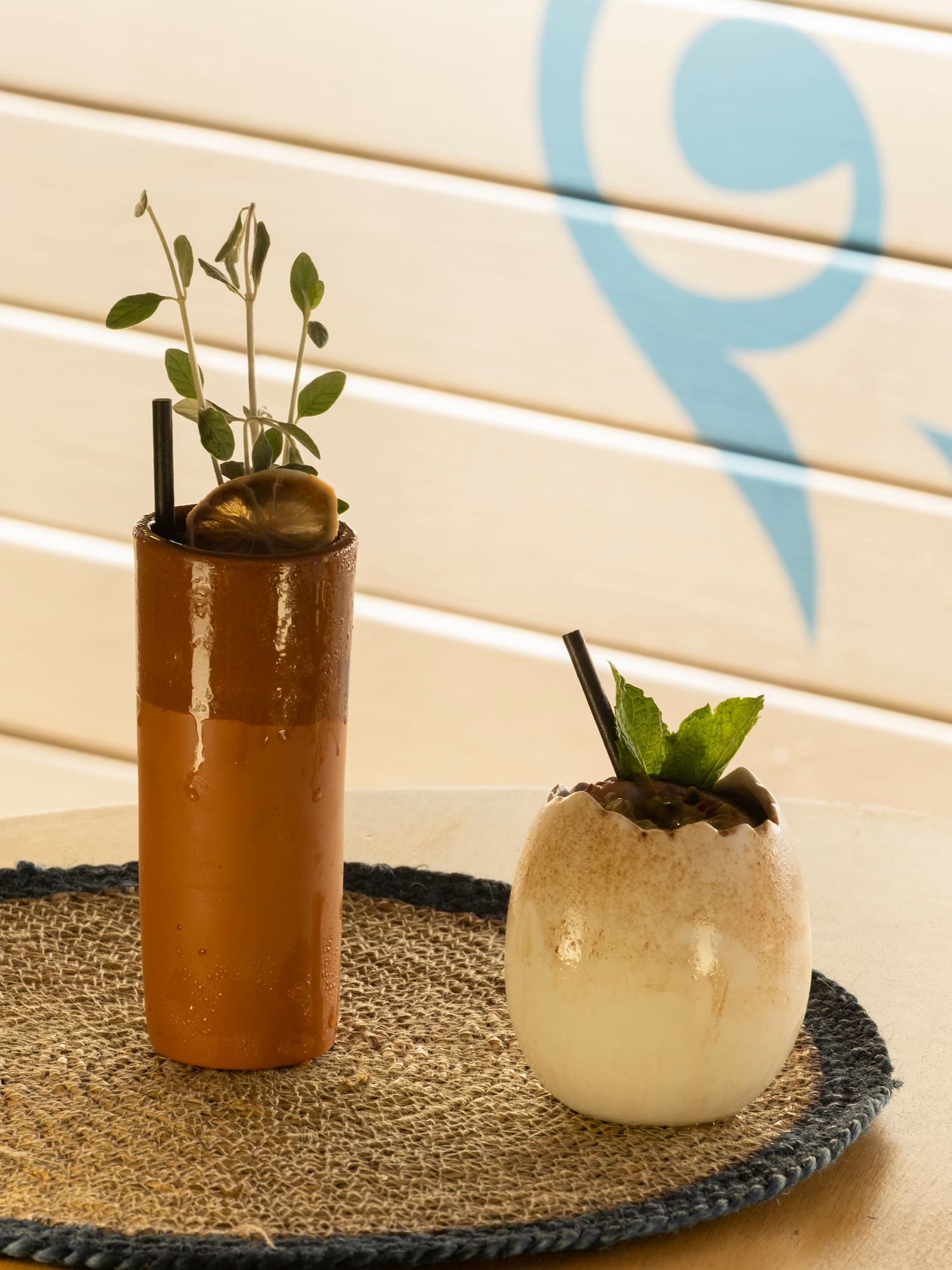 a brown cup with a plant in it and a white egg with straws