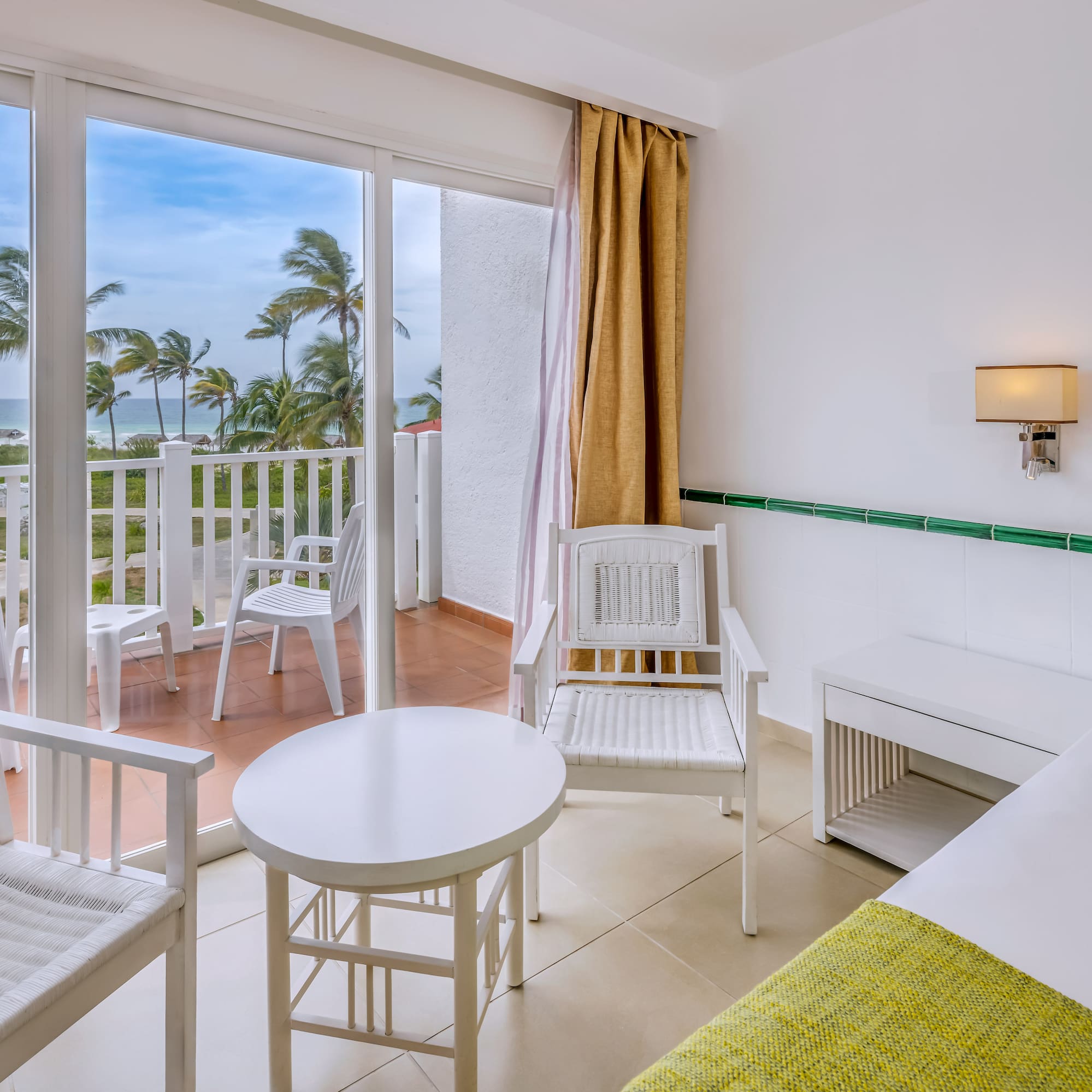 a room with a balcony and chairs and a table