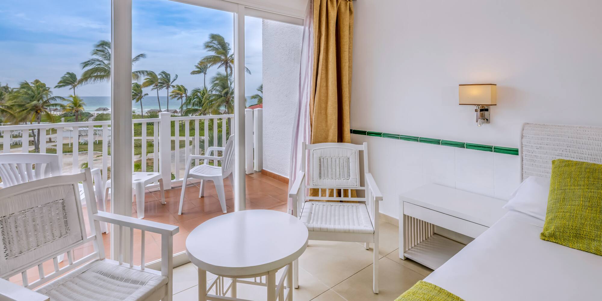 a room with a balcony and chairs and a table