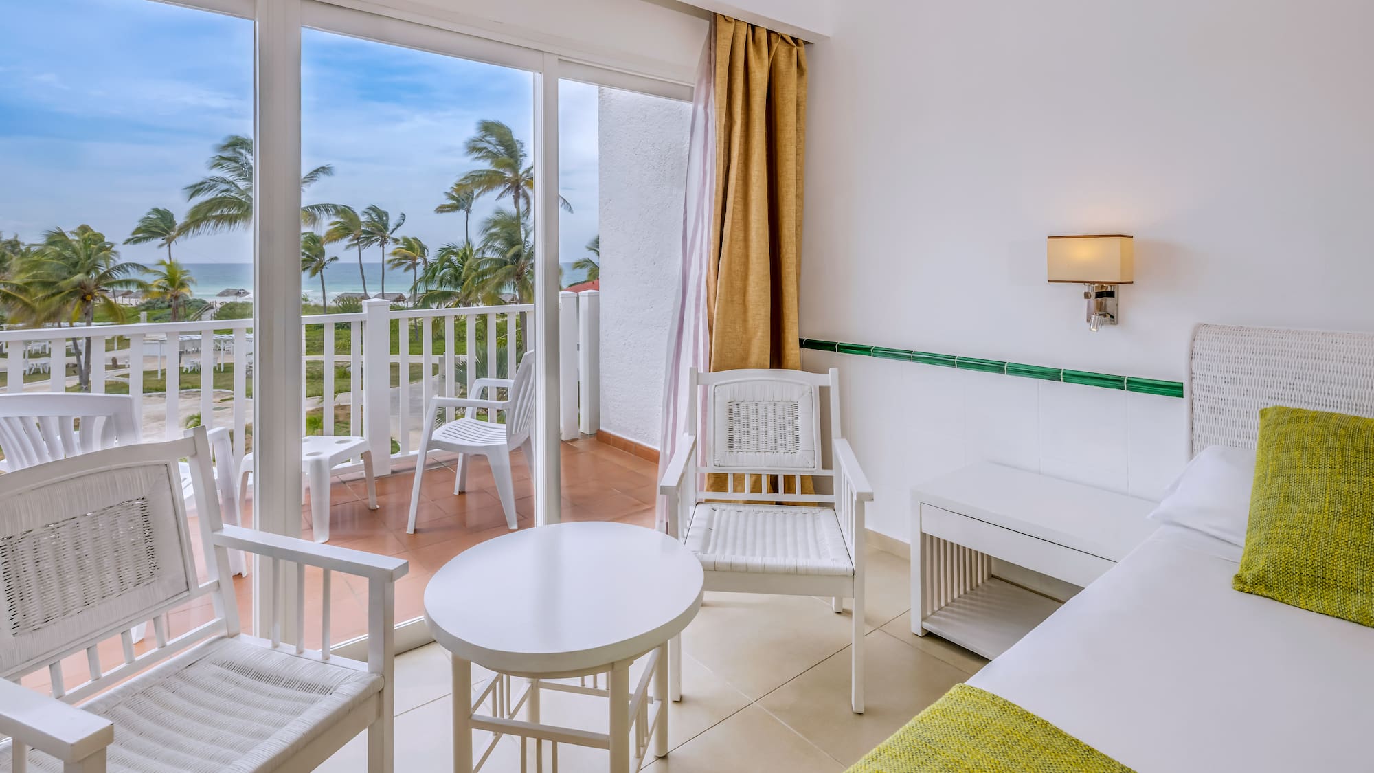 a room with a balcony and chairs and a table