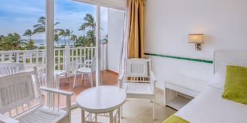a room with a balcony and chairs and a table