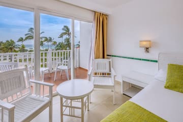 a room with a balcony and chairs and a table