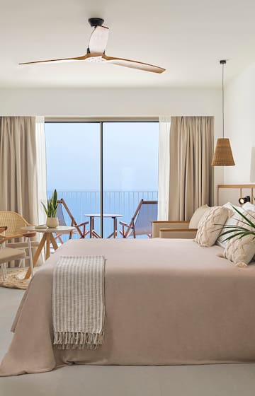 a bedroom with a large bed and a ceiling fan