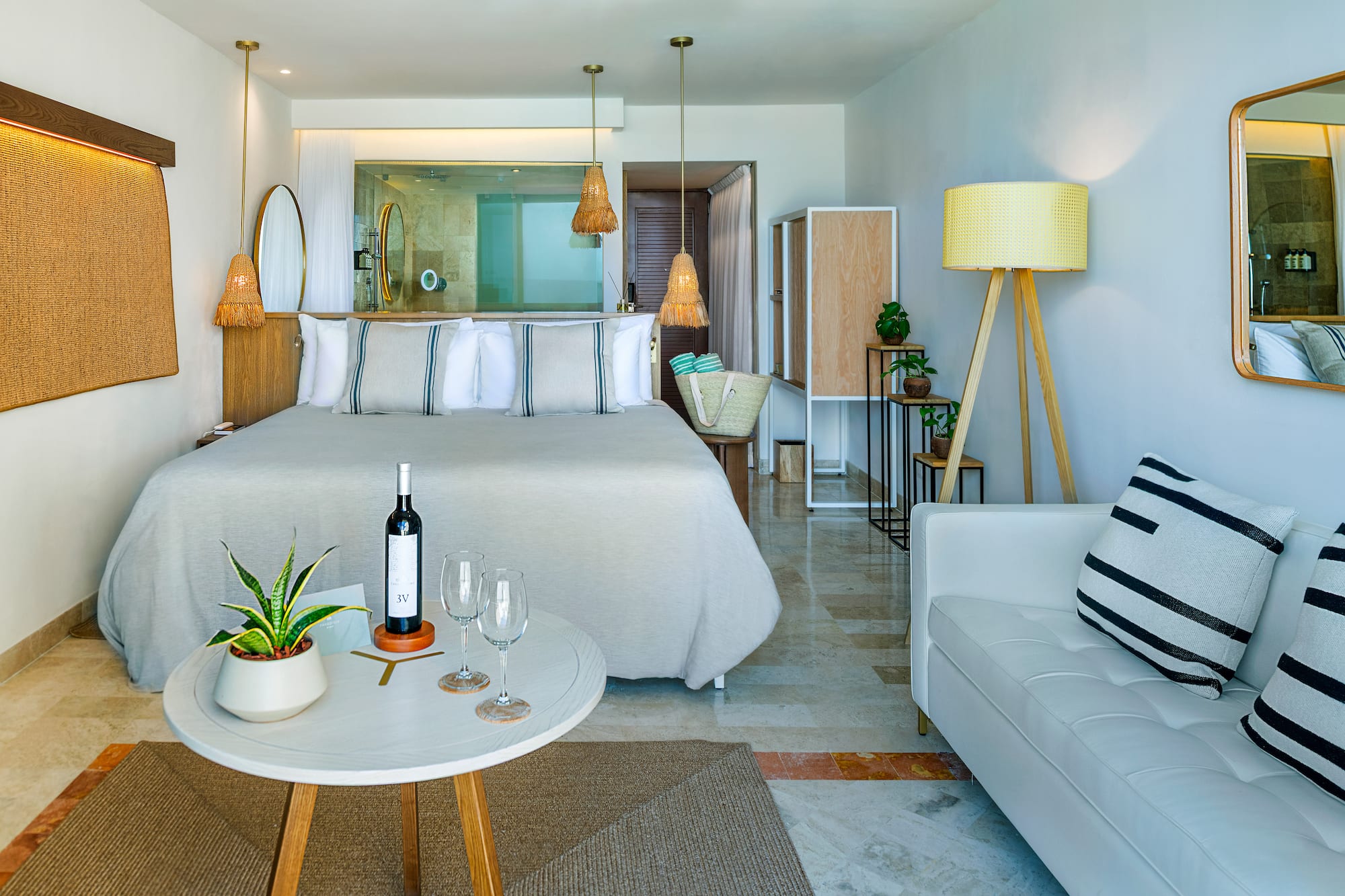 a room with a bed and a table and a wine bottle