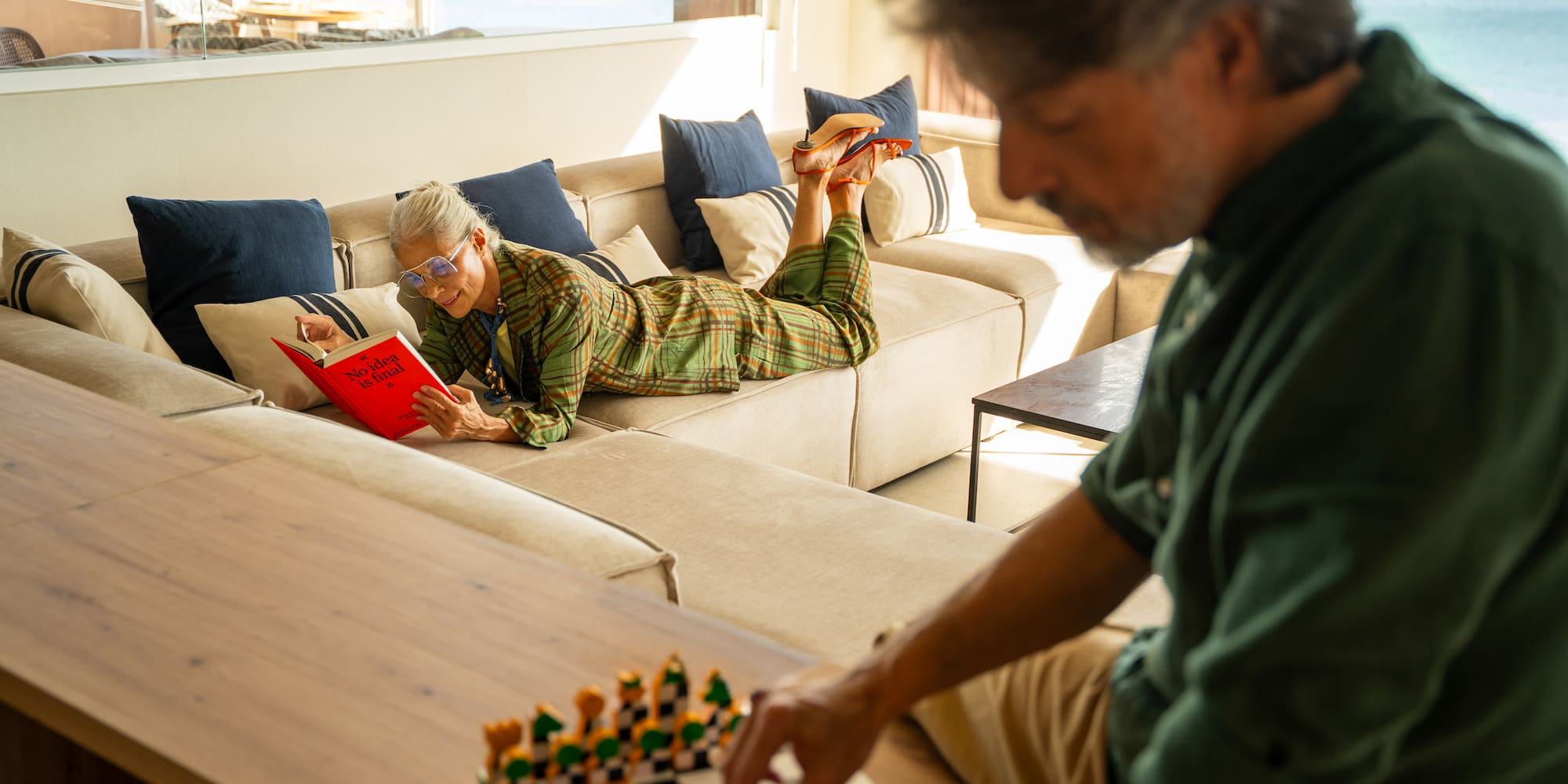 a man and woman lying on a couch and reading a book