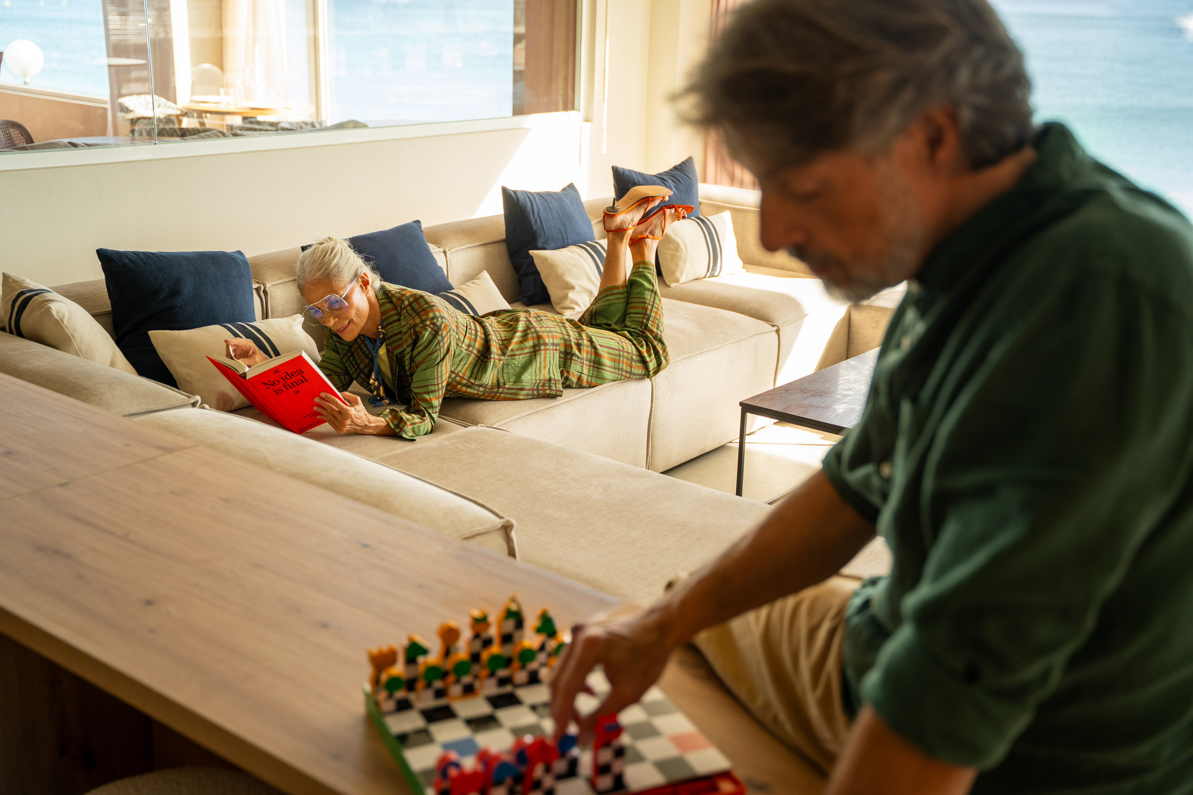 a man and woman lying on a couch and reading a book