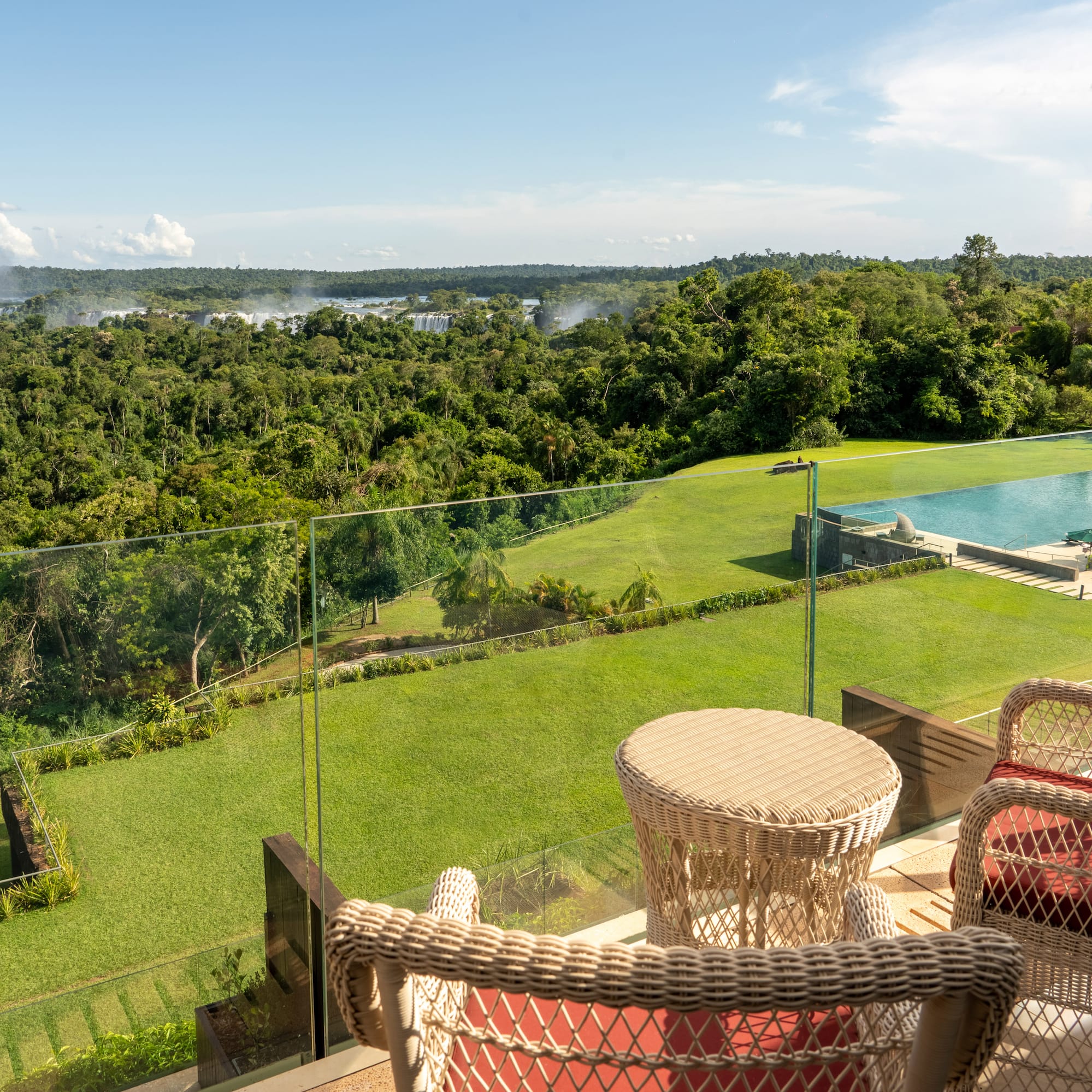a view of a pool and a lawn from a balcony