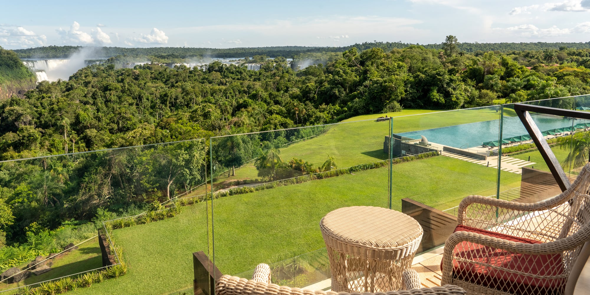 a view of a pool and a lawn from a balcony