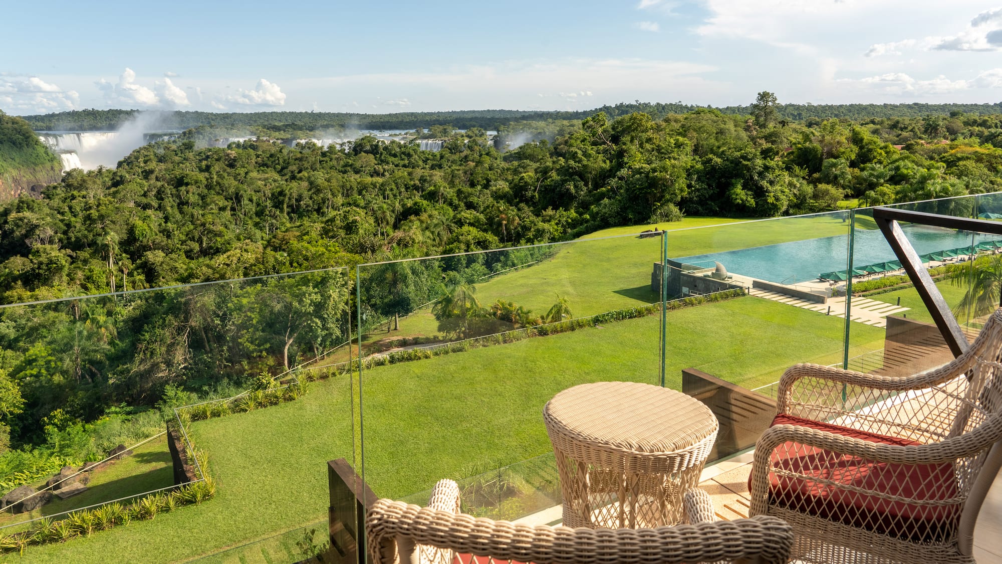 a view of a pool and a lawn from a balcony