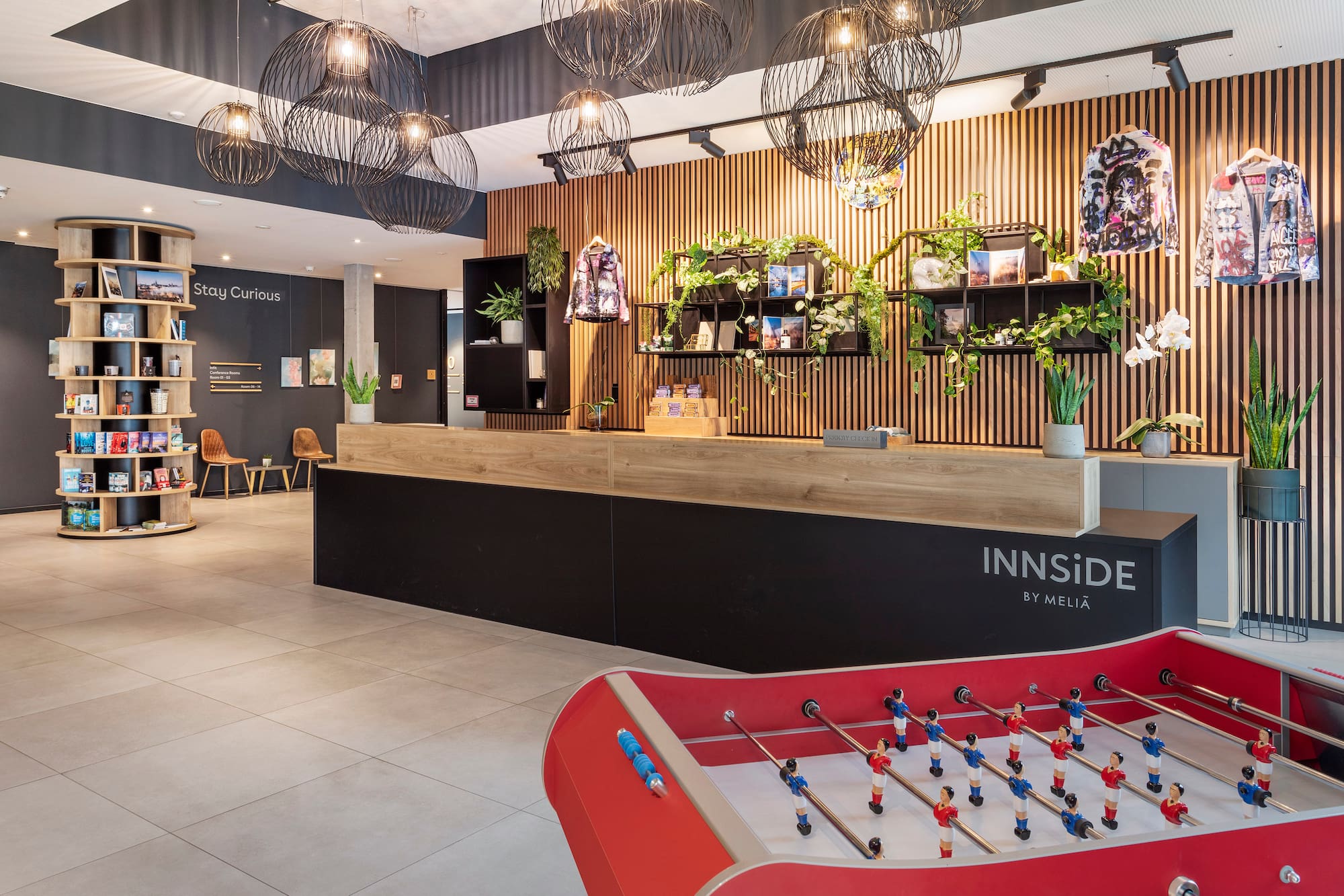 Modern INNSiDE by Meliã hotel lobby with reception desk and foosball table.