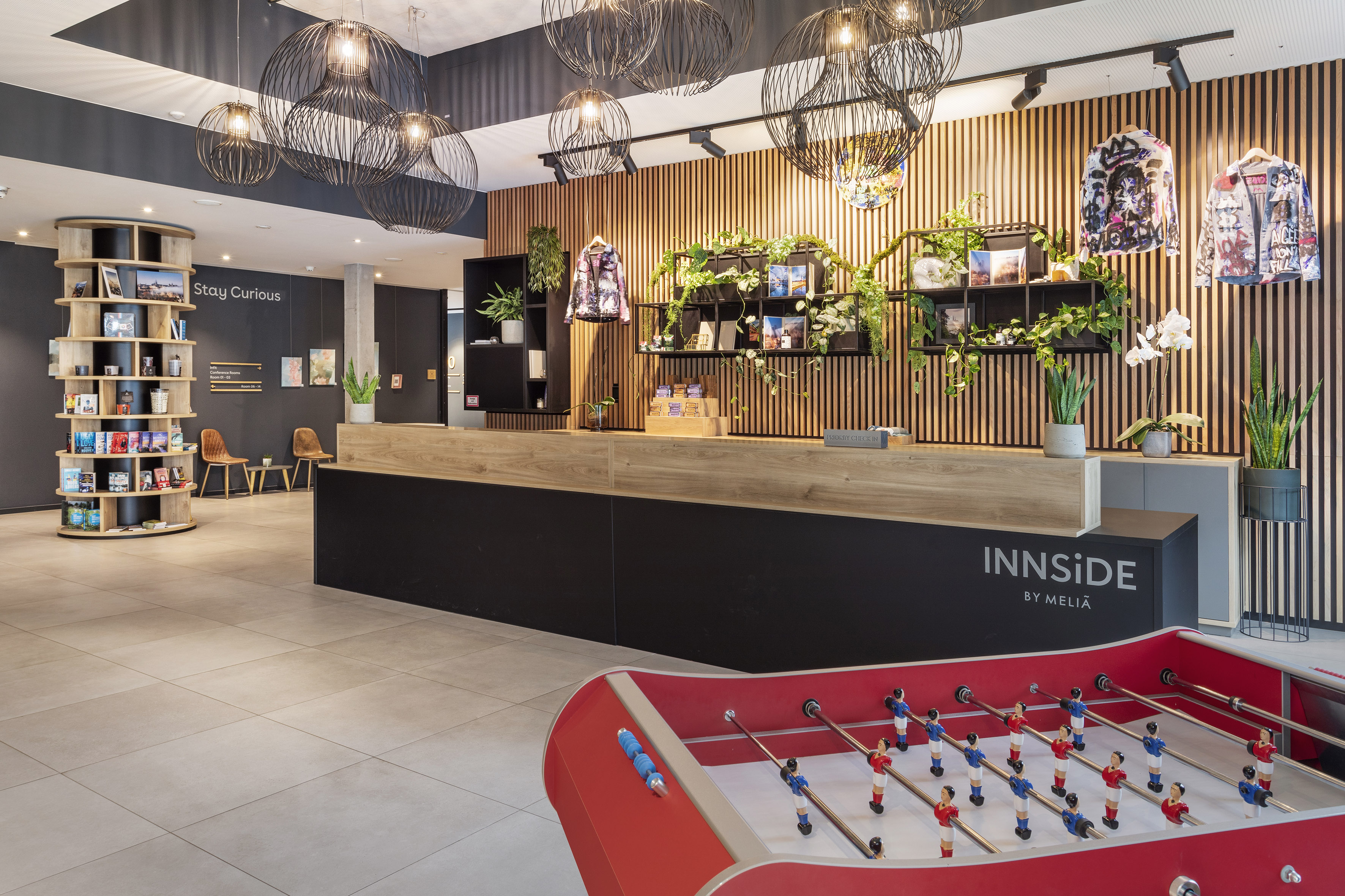 Modern INNSiDE by Meliã hotel lobby with reception desk and foosball table.