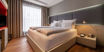 a bed with pillows and a lamp in a room