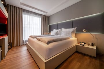 a bed with pillows and a lamp in a room