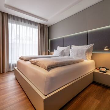 a bed with pillows and a lamp in a room