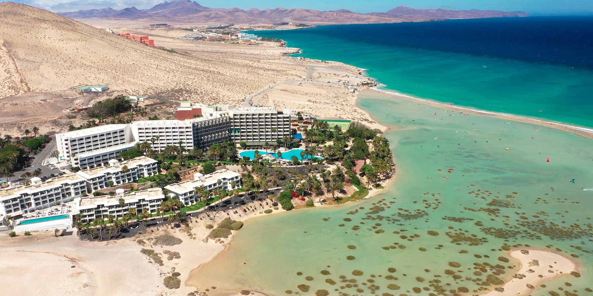 a beach with buildings and a pool