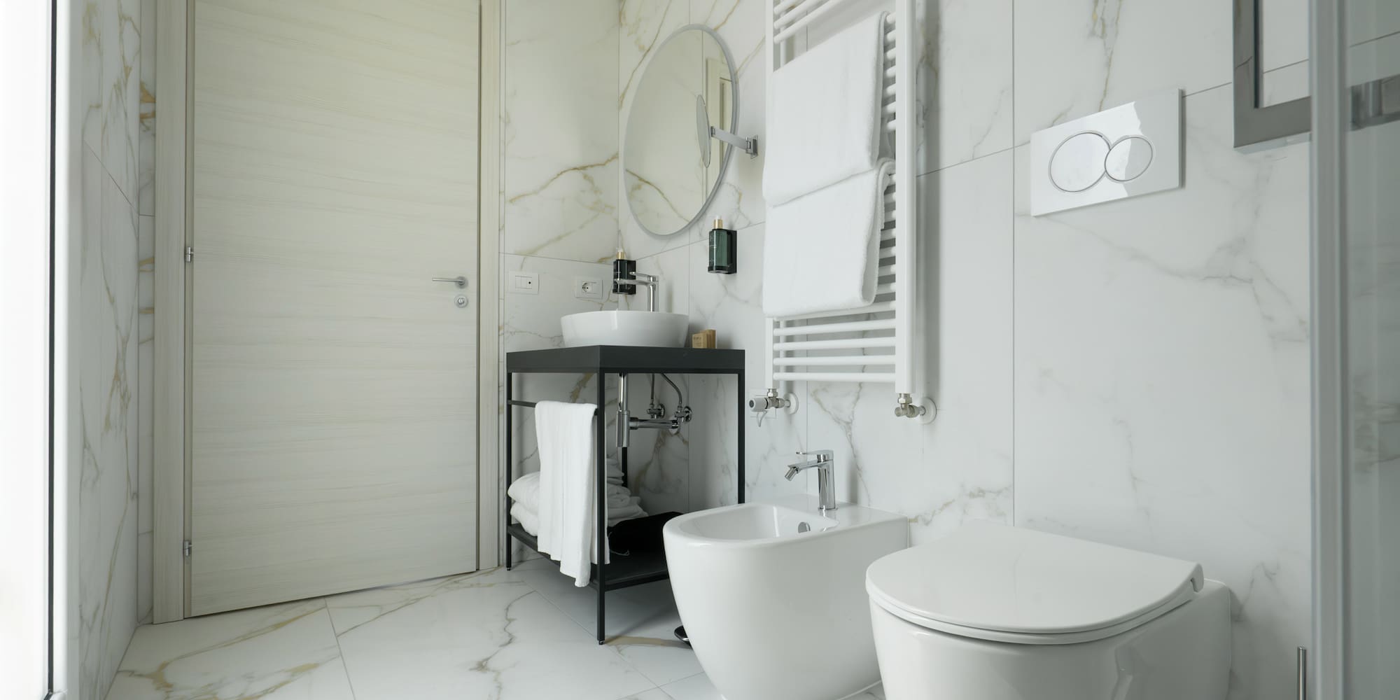 a bathroom with marble walls and a sink and toilet