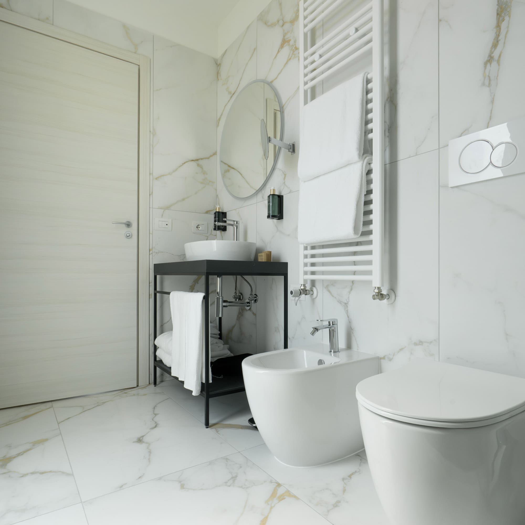 a bathroom with marble walls and a sink and toilet