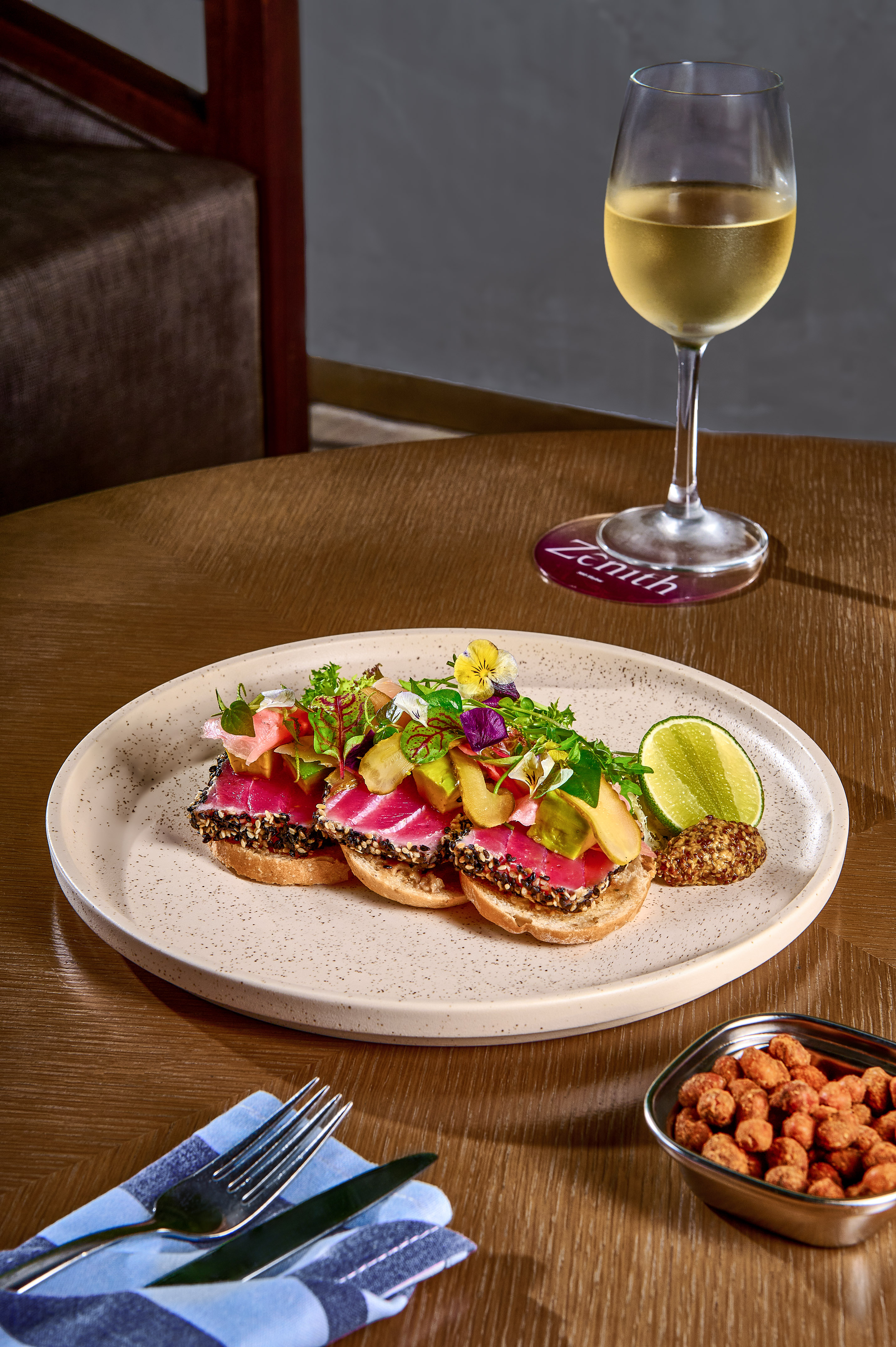 Sesame-crusted seared tuna tartine, avocado, greens, lime, white wine.