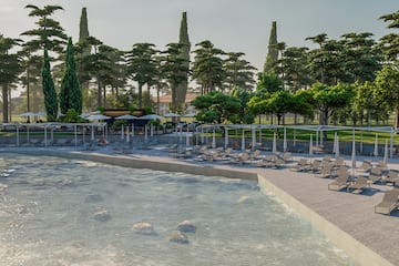 a pool with lounge chairs and umbrellas by a pool