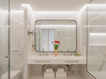 a bathroom with a mirror and a vase of flowers