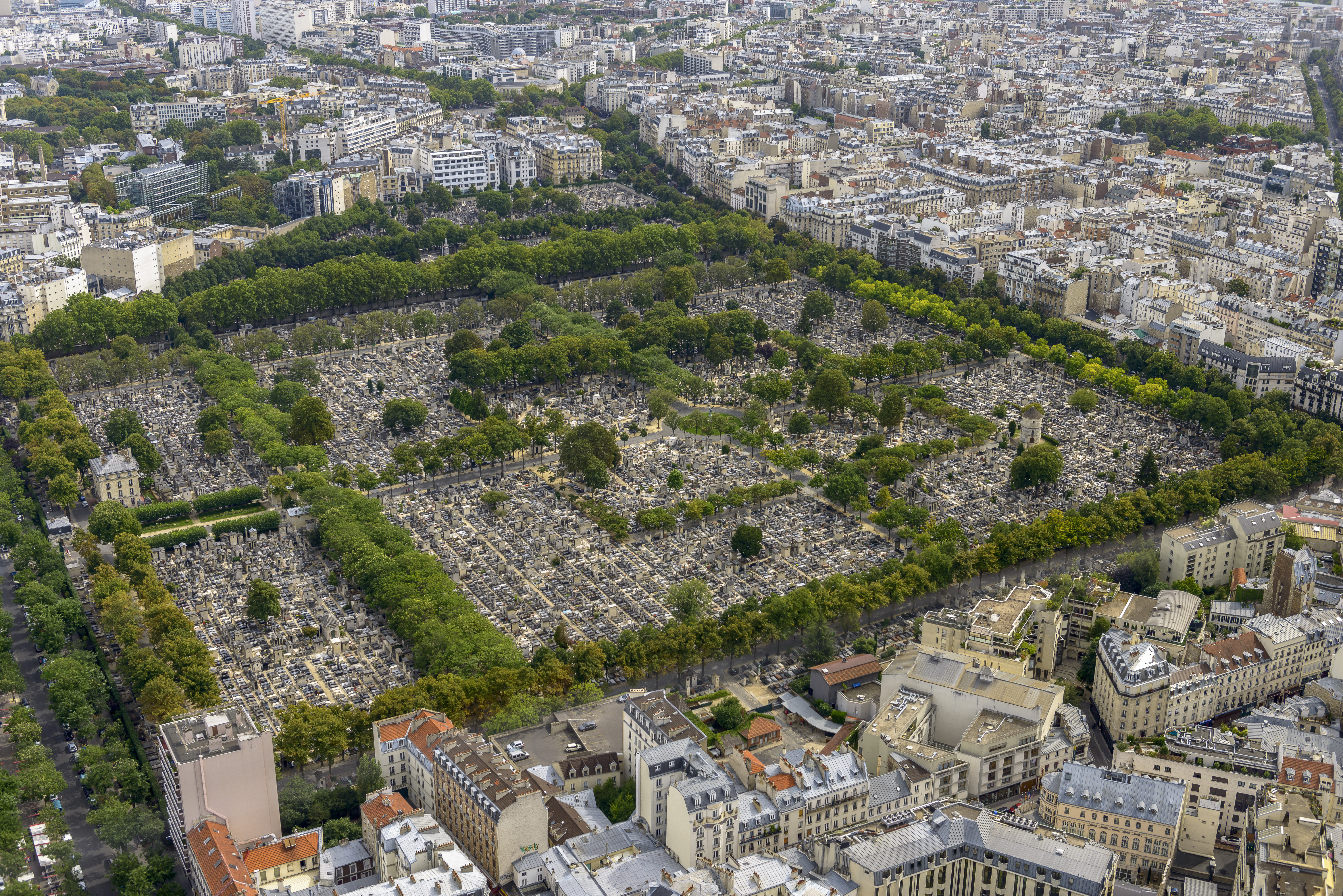Vista aérea del Cementerio de Montparnasse, París, con tumbas y edificios urbanos.