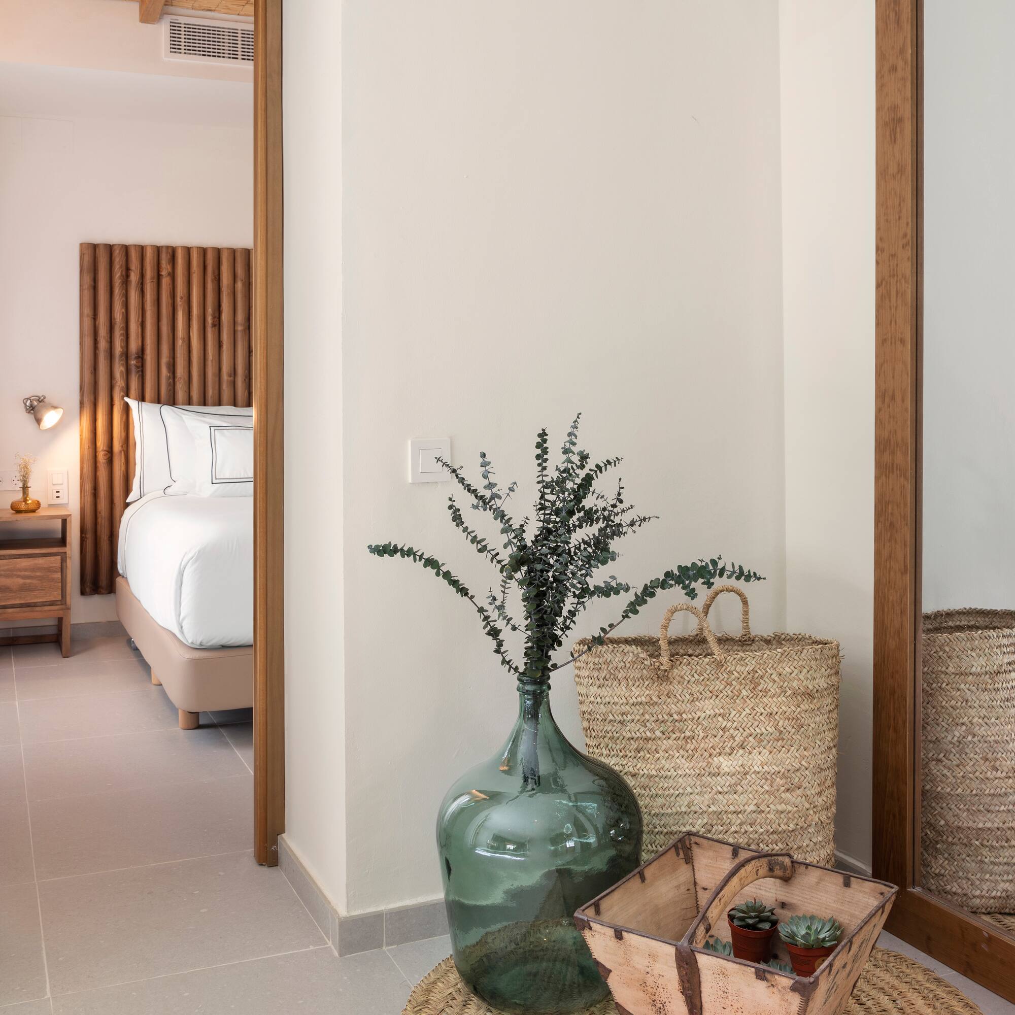 a vase with plants in it next to a basket