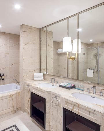 a bathroom with marble countertops and a tub