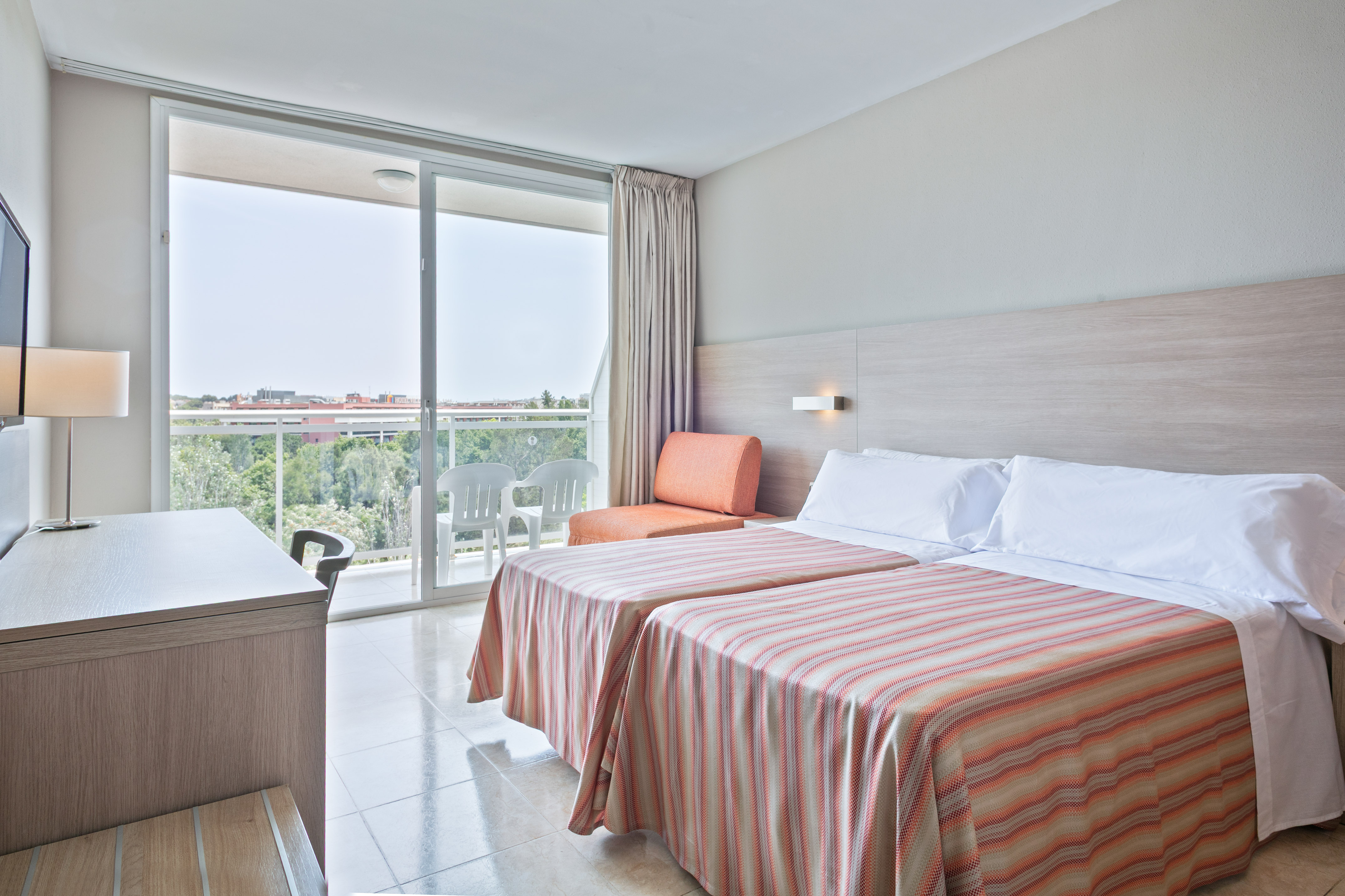 a room with two beds and a desk