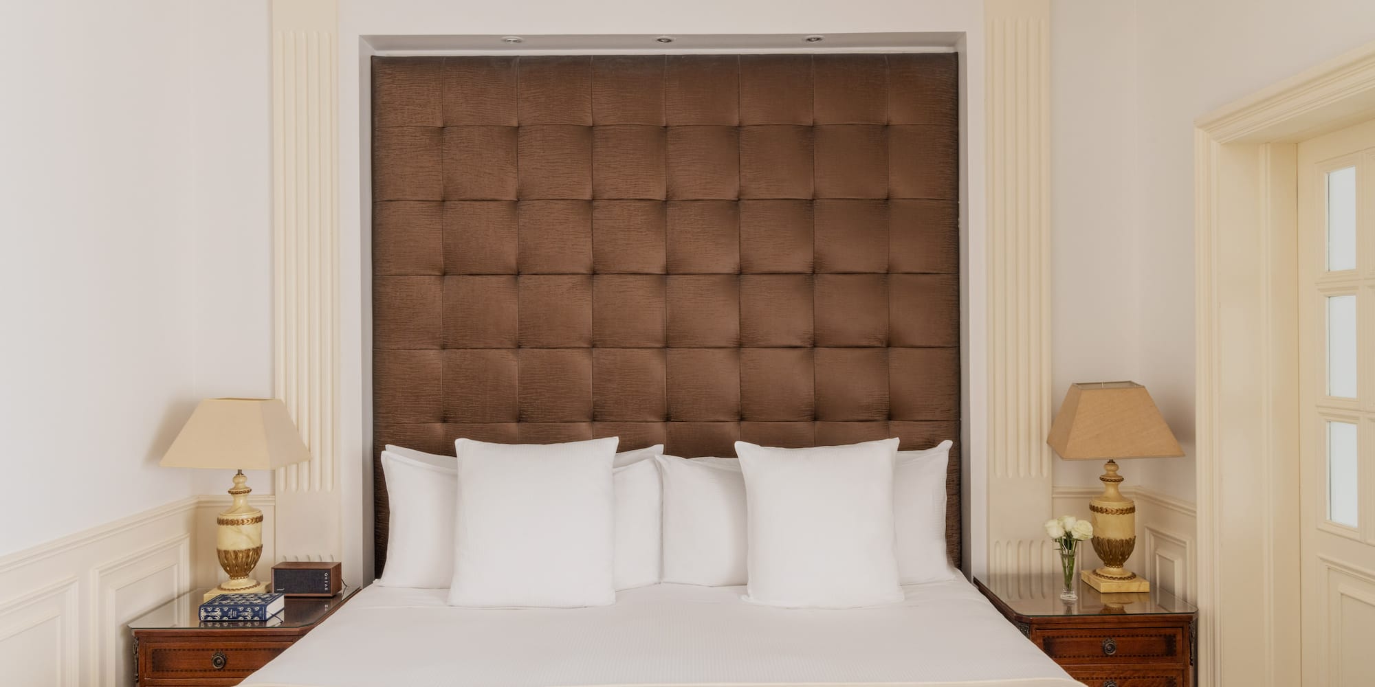 a bed with pillows and lamps in a room