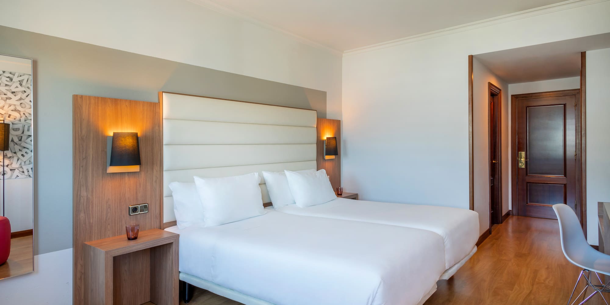 a room with two beds and a wood floor