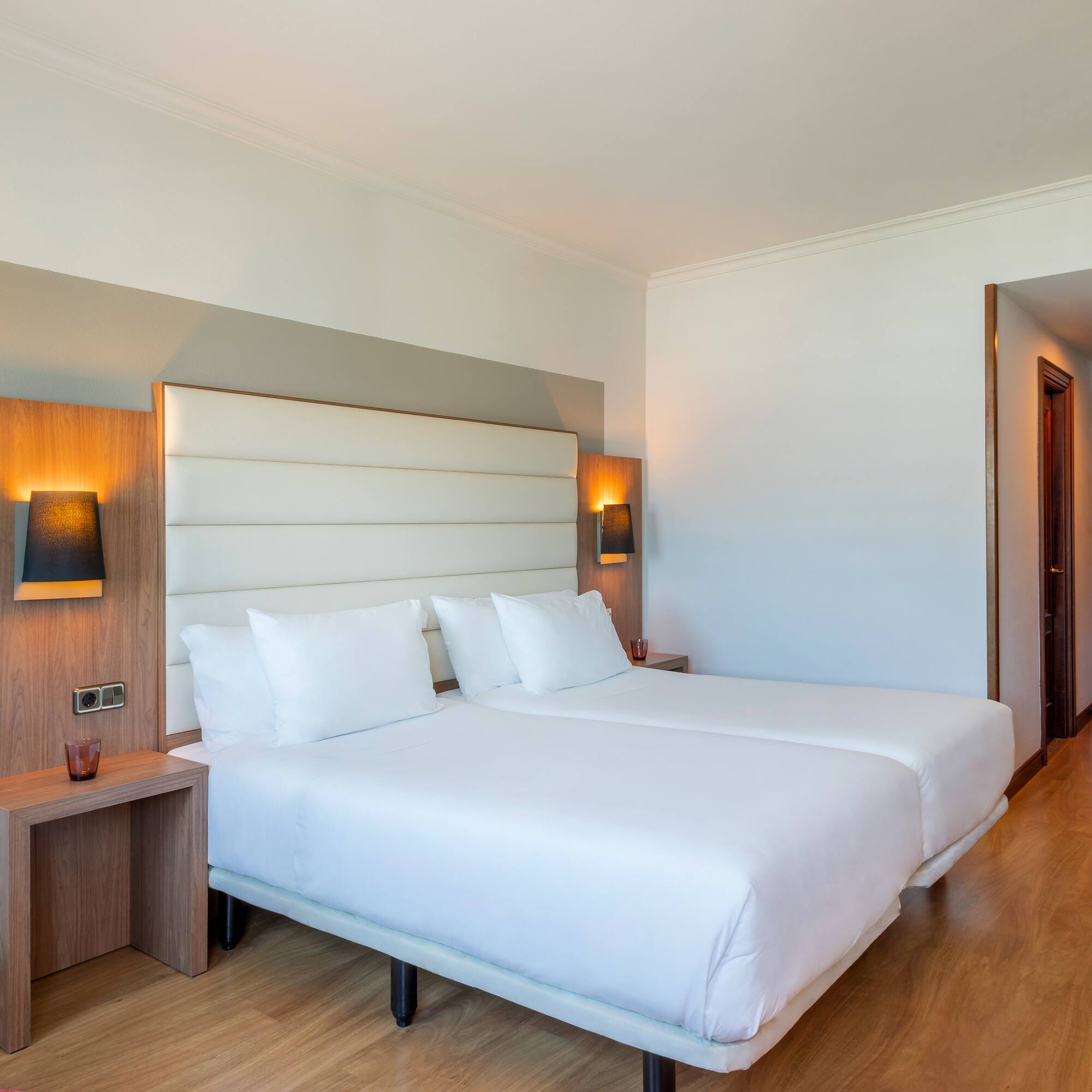 a room with two beds and a wood floor