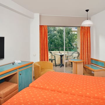 a room with two beds and a television