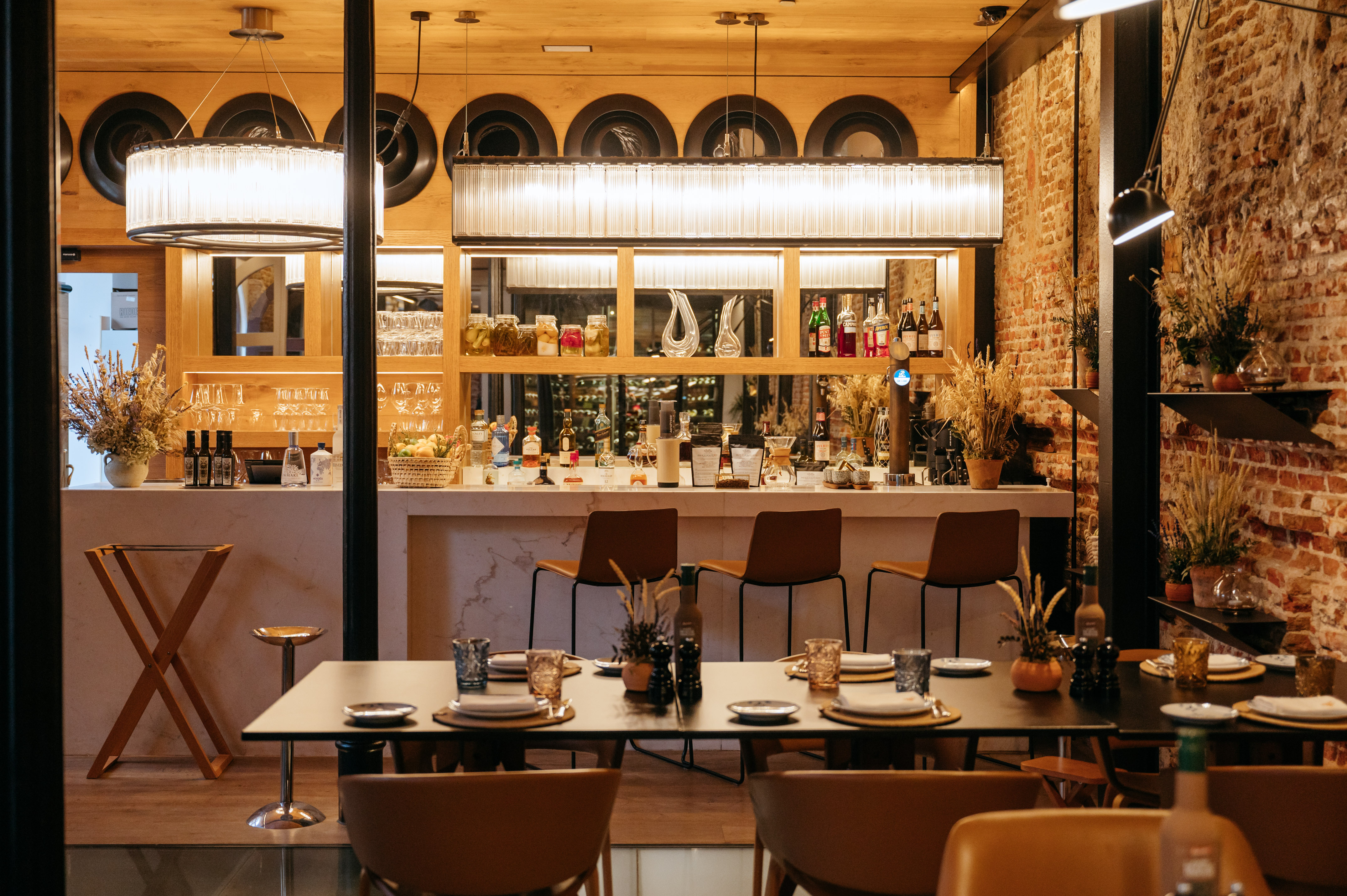 Modern restaurant bar and dining area with brick walls and ambient lighting.