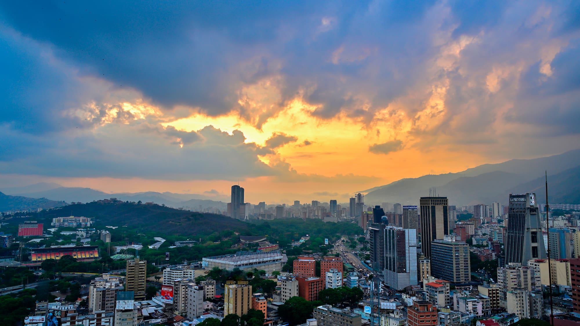 a city with many buildings and mountains in the background