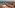 Rooftop terrace with ocean, beach, palm trees, and luxury resort view.