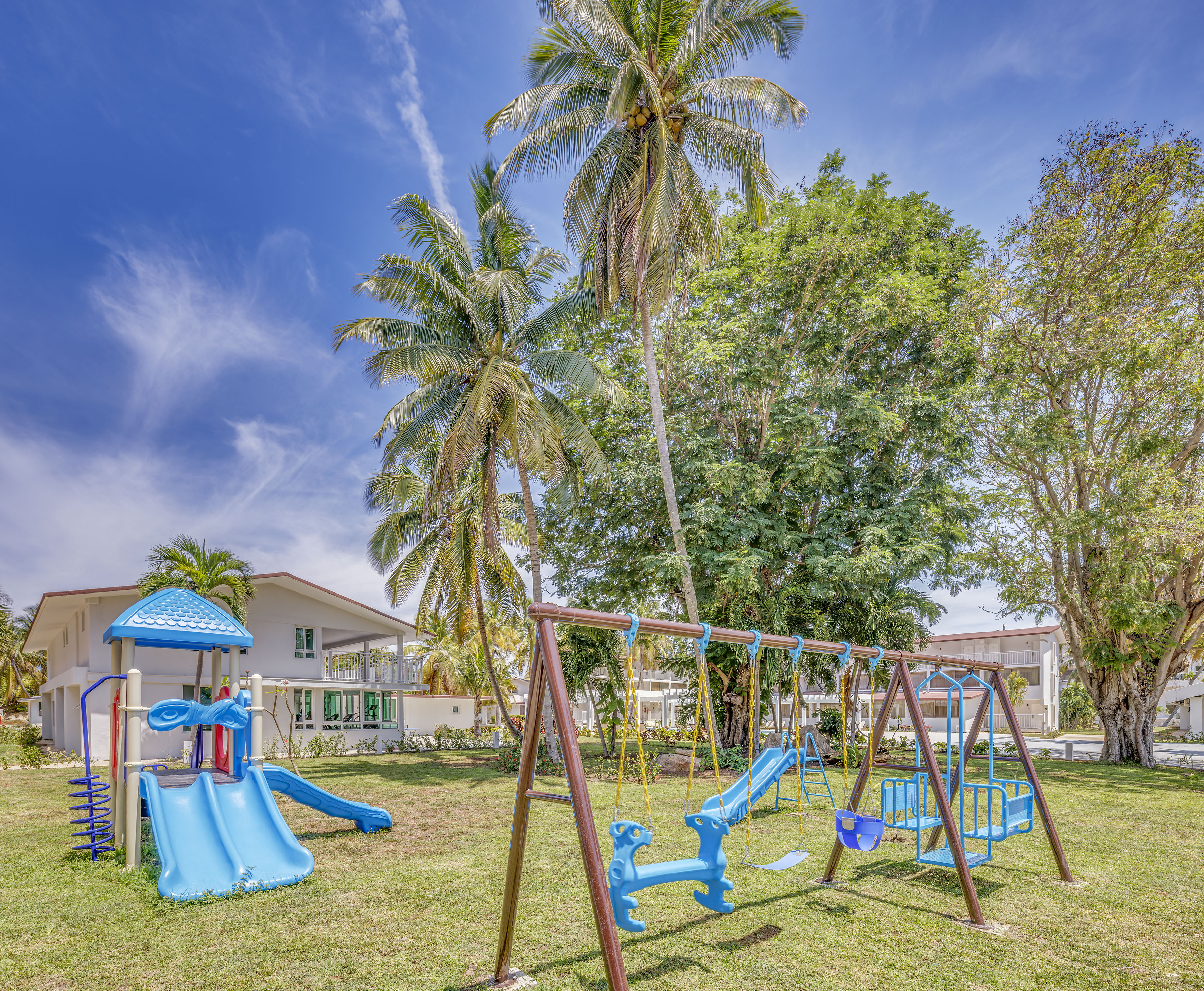 a playground with a slide and a slide in a yard