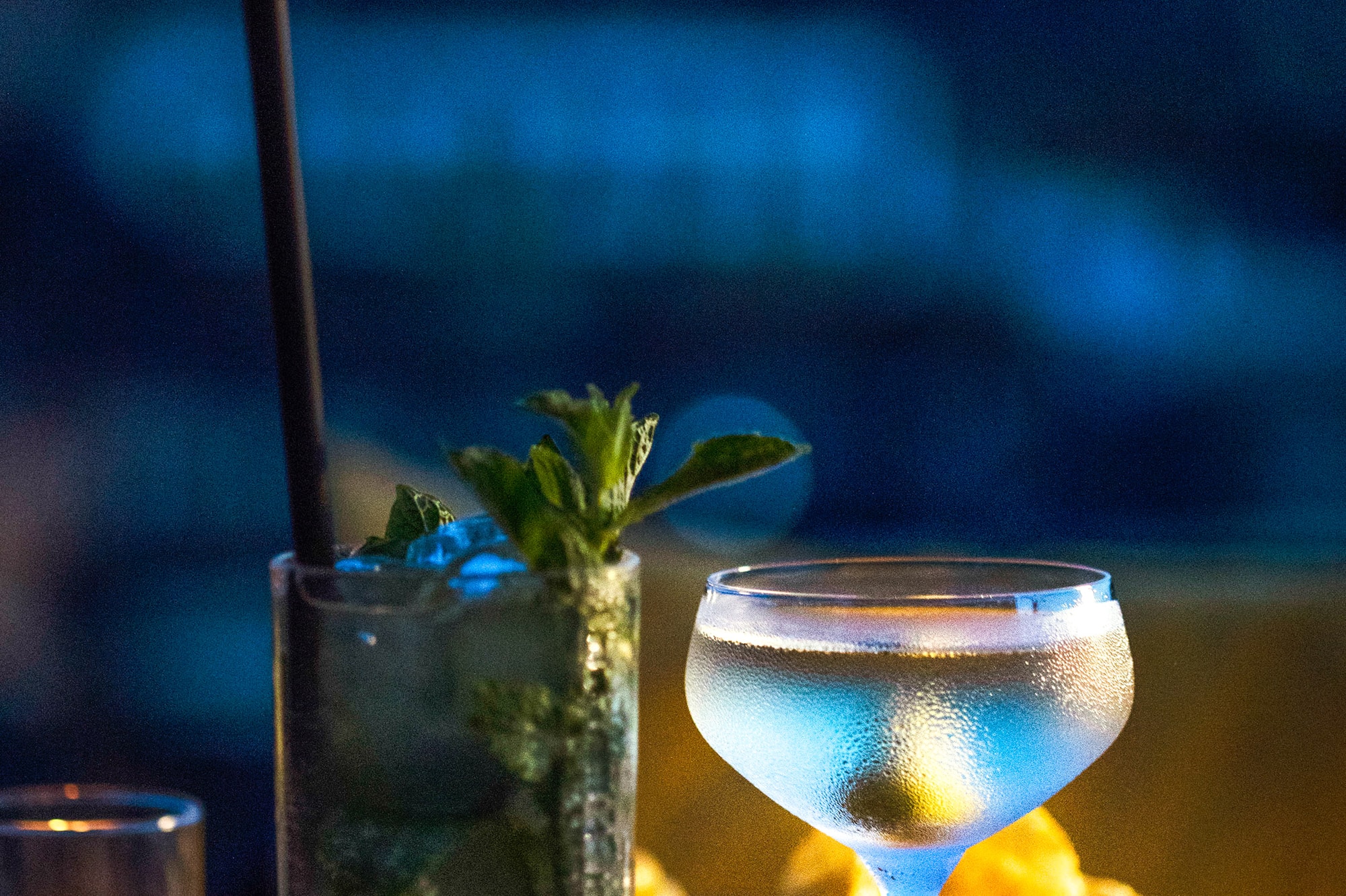 a glass of liquid and a drink on a table.