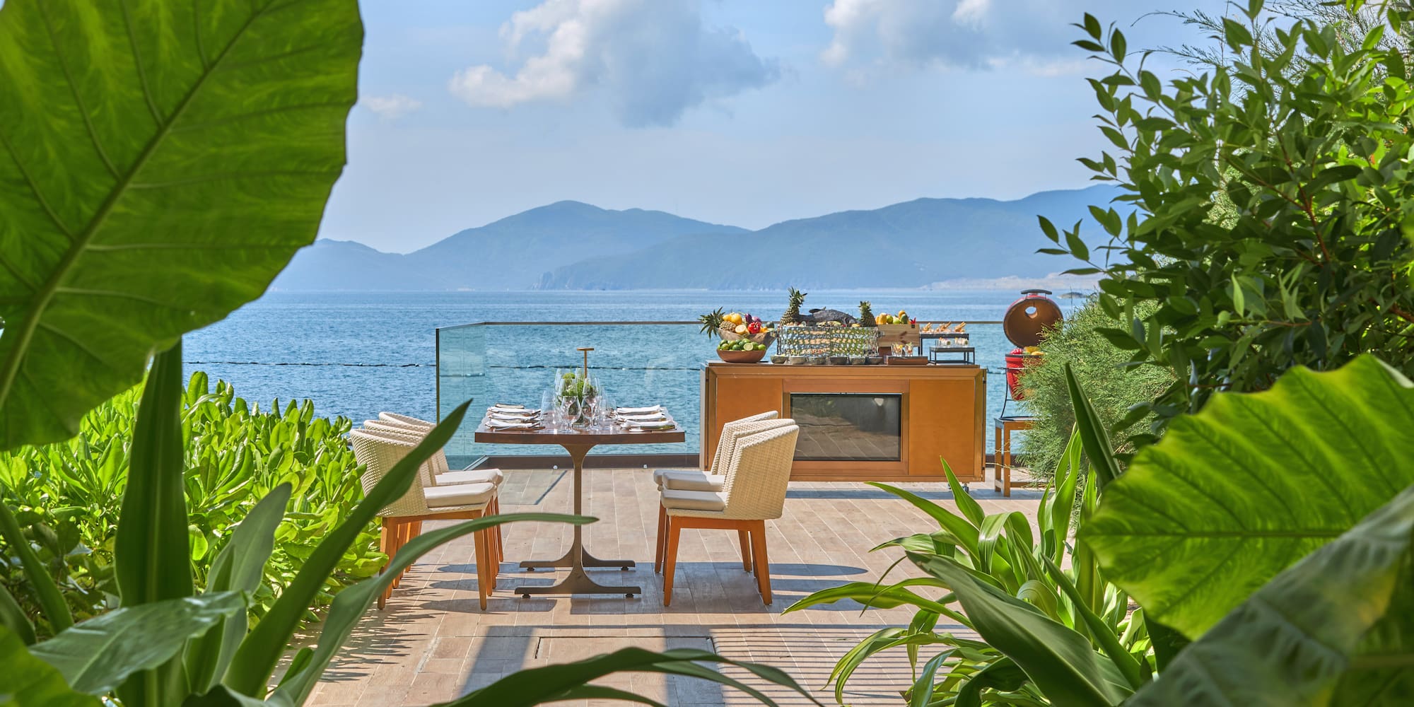 a table and chairs on a patio overlooking a body of water